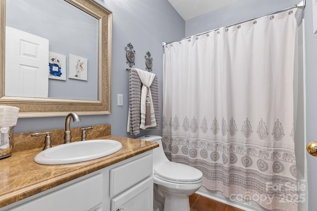 bathroom featuring curtained shower, tile patterned flooring, vanity, and toilet