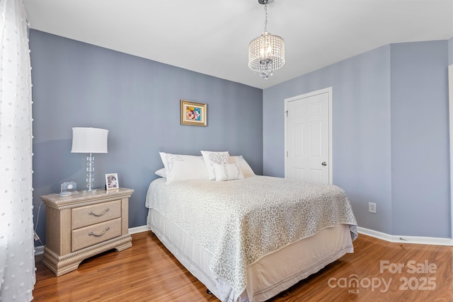 bedroom featuring a notable chandelier and wood-type flooring