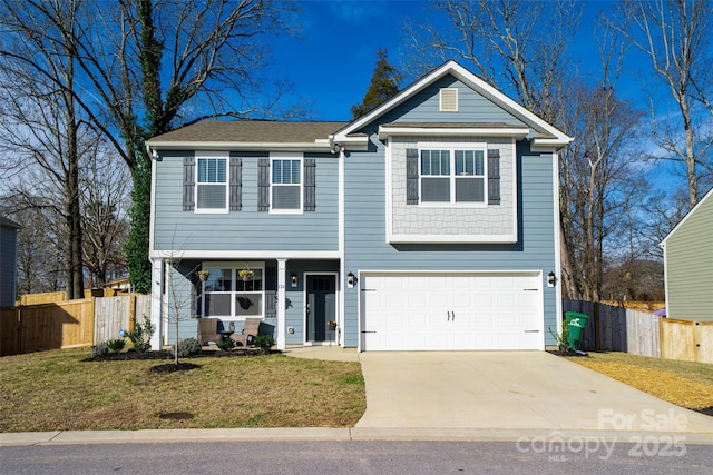 traditional-style house featuring driveway, an attached garage, fence, and a front yard