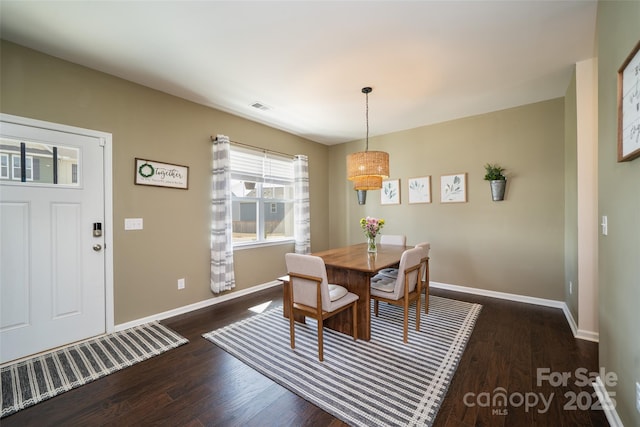 dining space featuring dark wood-style floors, visible vents, and baseboards