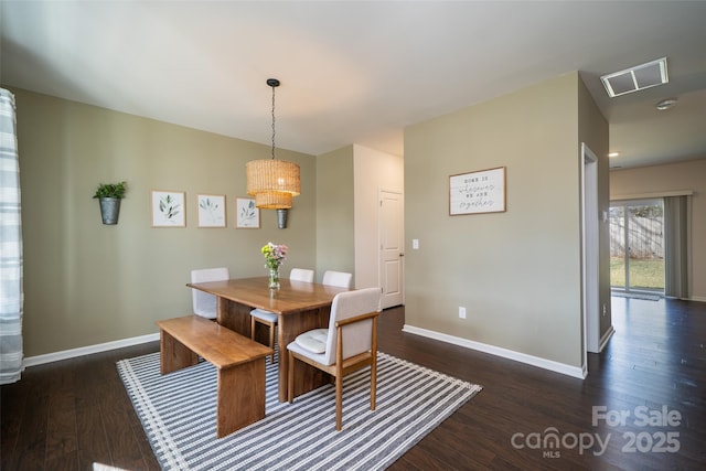 dining space with dark wood finished floors, visible vents, and baseboards