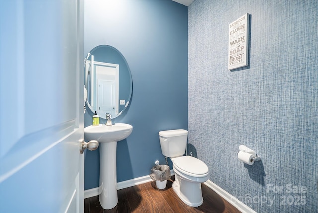 bathroom with a sink, wood finished floors, toilet, and baseboards