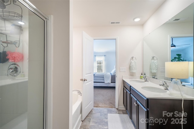 ensuite bathroom with a shower stall, a sink, visible vents, and connected bathroom