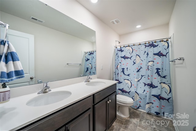 bathroom featuring double vanity, visible vents, and a sink