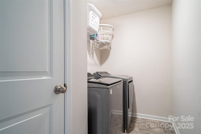 washroom with washer and dryer, laundry area, and baseboards