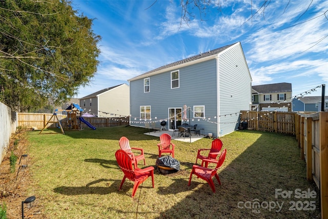 back of property with an outdoor fire pit, a playground, a fenced backyard, a yard, and a patio area