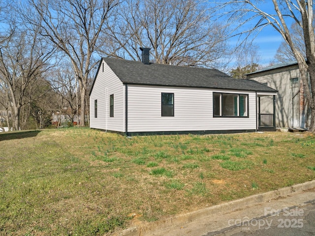 view of property exterior featuring a chimney, a lawn, and roof with shingles