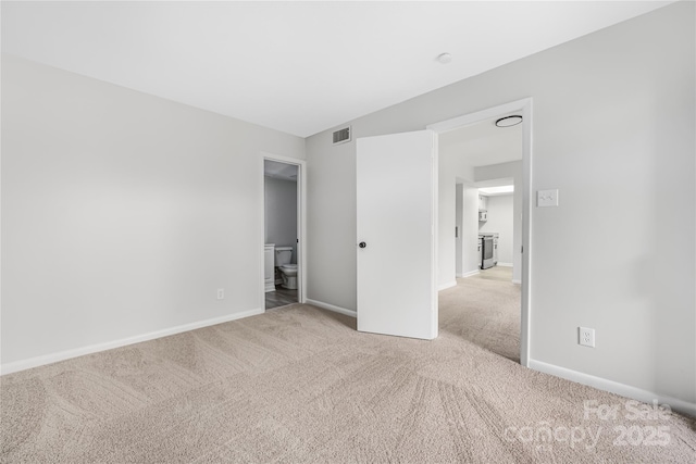 unfurnished bedroom featuring baseboards, carpet floors, visible vents, and ensuite bath