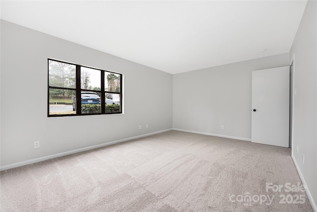 spare room featuring baseboards and carpet