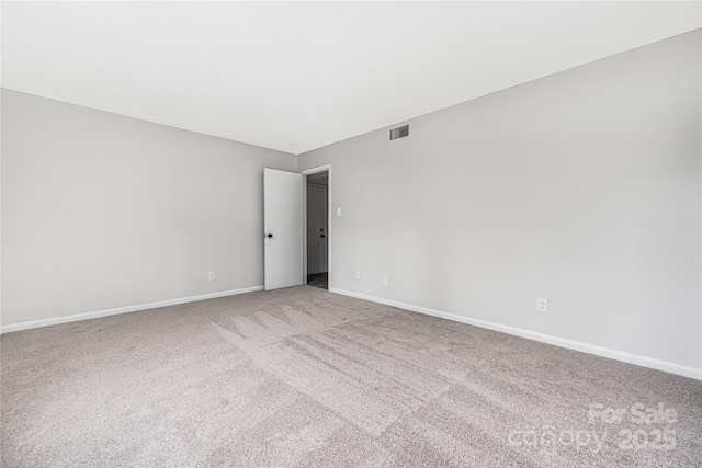 empty room with visible vents, baseboards, and carpet