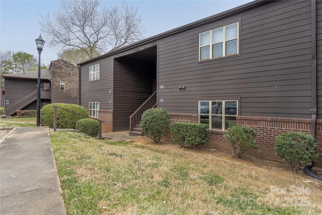 view of home's exterior featuring brick siding and a lawn