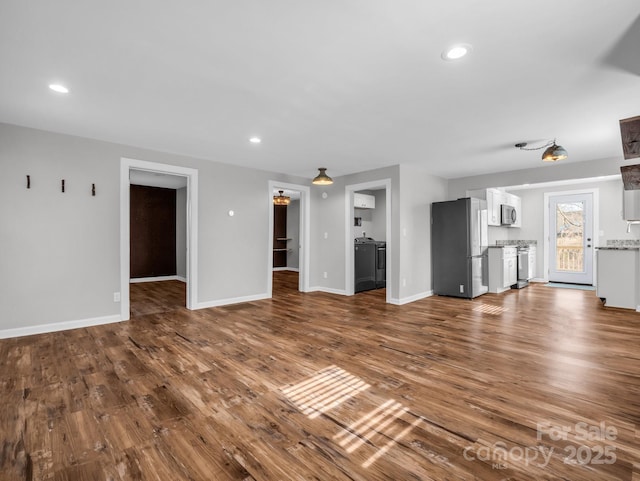 unfurnished living room with dark wood-type flooring, recessed lighting, and baseboards