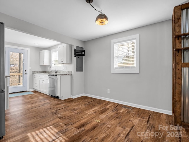 kitchen with wood finished floors, baseboards, white cabinets, light stone countertops, and dishwasher