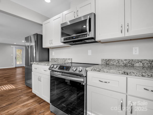 kitchen featuring light stone counters, dark wood-style flooring, stainless steel appliances, white cabinetry, and recessed lighting