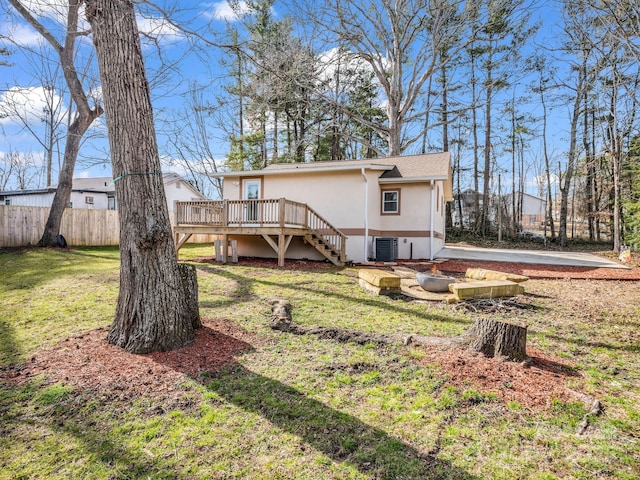 back of house featuring stucco siding, a lawn, stairway, fence, and a wooden deck