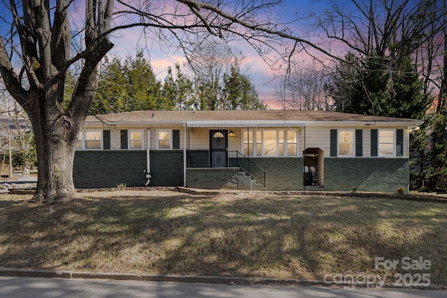 ranch-style home featuring brick siding and a front lawn