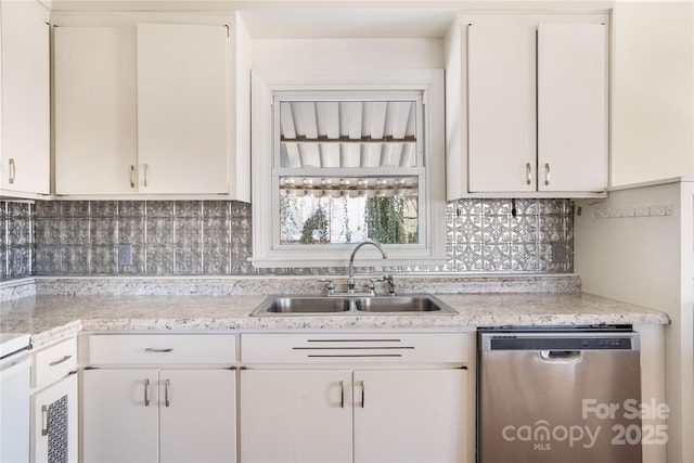 kitchen with a sink, backsplash, white cabinets, and dishwasher