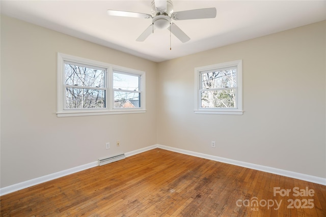 spare room with ceiling fan, wood-type flooring, and baseboards