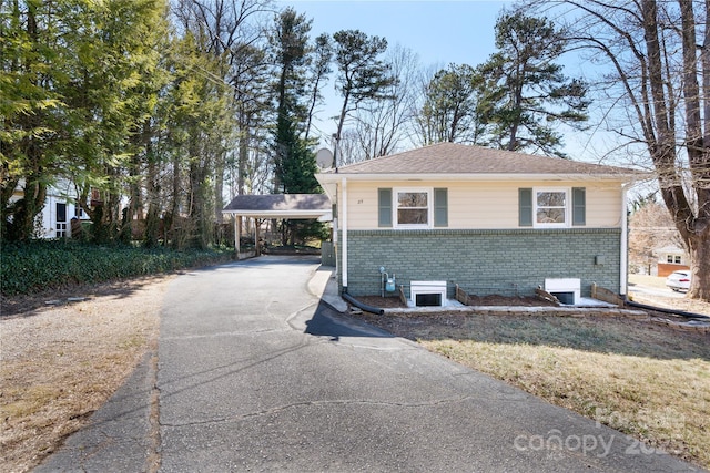 view of home's exterior featuring aphalt driveway and brick siding