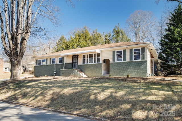 ranch-style home featuring brick siding and a front lawn