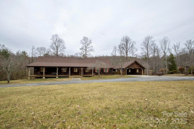 exterior space with aphalt driveway and a front yard