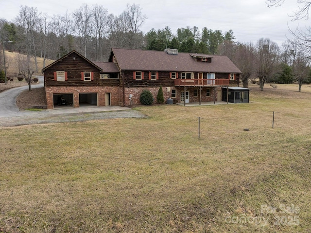 view of front of home featuring a garage, driveway, a front lawn, and a wooden deck