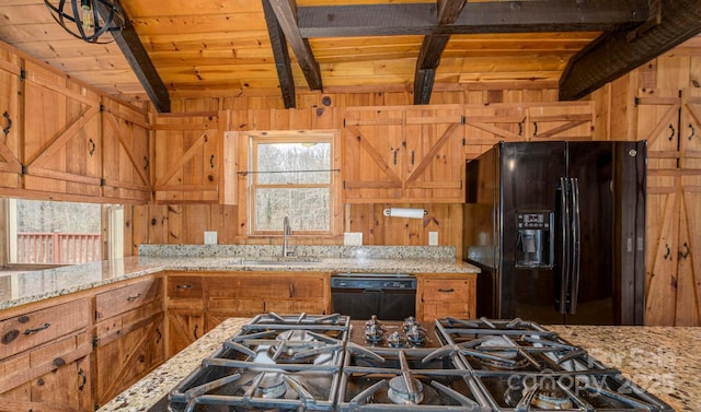 kitchen featuring black appliances, wooden walls, beam ceiling, and a sink