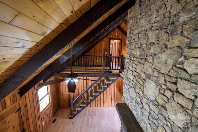 interior space with visible vents, wooden walls, lofted ceiling with beams, and wood finished floors