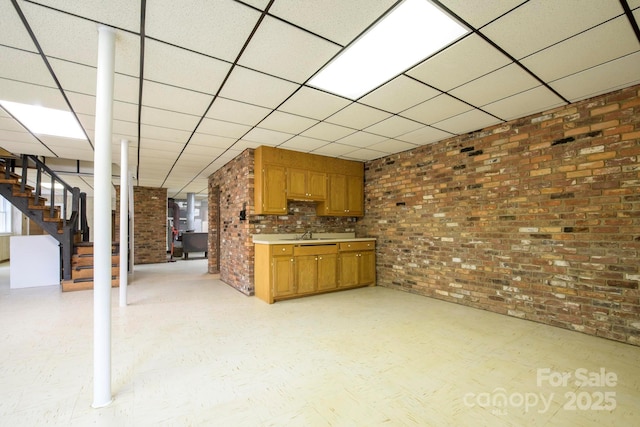 interior space with light countertops, brown cabinetry, brick wall, and light floors