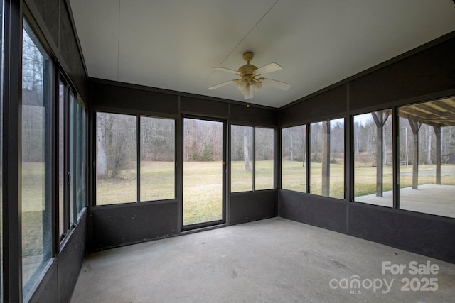 unfurnished sunroom featuring a ceiling fan