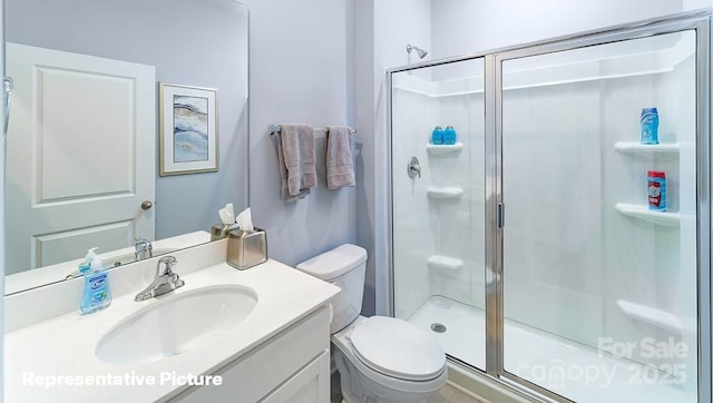 bathroom with toilet, a shower with door, and vanity