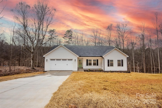 single story home featuring a garage, driveway, a shingled roof, and a yard