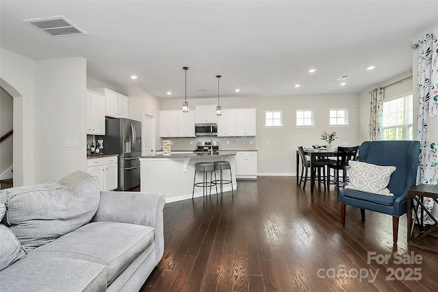 805 Deep River Way, Waxhaw, NC 28173 - living area featuring visible vents, dark wood-style floors, baseboards, arched walkways, and recessed lighting