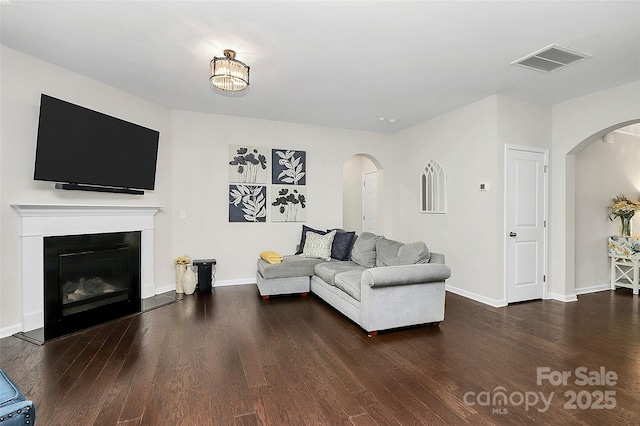 805 Deep River Way, Waxhaw, NC 28173 - living room featuring wood finished floors, visible vents, a glass covered fireplace, and arched walkways