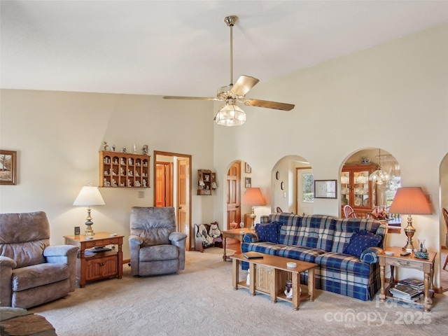 living room featuring ceiling fan, carpet flooring, and a towering ceiling