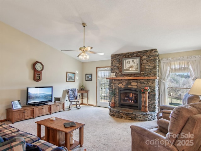 living room with ceiling fan, a stone fireplace, light carpet, and lofted ceiling