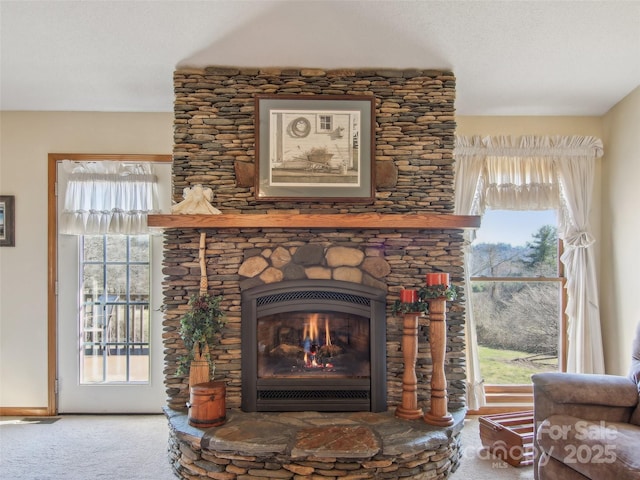 interior details featuring carpet, a stone fireplace, and a textured ceiling