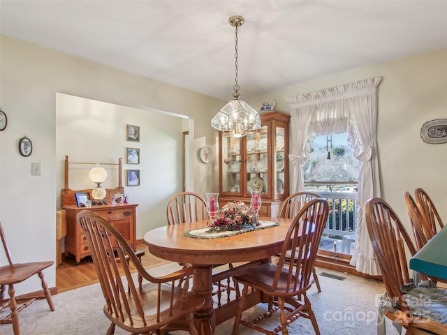 dining room with light wood-type flooring and a notable chandelier