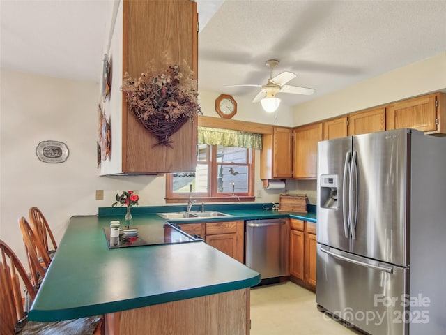 kitchen with stainless steel appliances, a textured ceiling, ceiling fan, sink, and kitchen peninsula