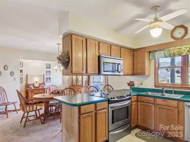 kitchen with sink, stainless steel appliances, kitchen peninsula, hanging light fixtures, and light colored carpet