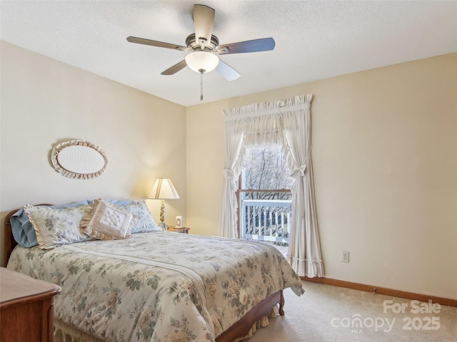 carpeted bedroom with ceiling fan and a textured ceiling