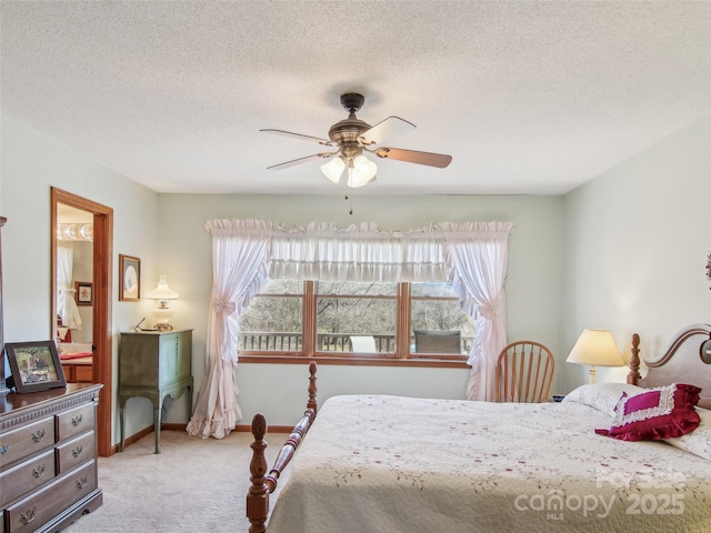 carpeted bedroom featuring ceiling fan and a textured ceiling