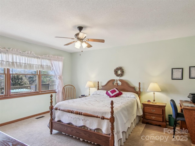 carpeted bedroom featuring ceiling fan and a textured ceiling