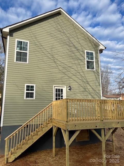 back of house featuring stairs and a wooden deck