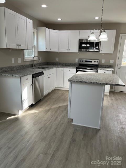 kitchen featuring appliances with stainless steel finishes, white cabinets, and a kitchen island