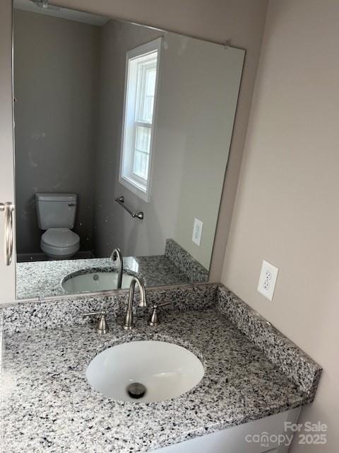 bathroom featuring toilet and vanity