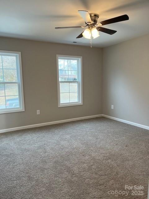 unfurnished room featuring carpet, ceiling fan, and baseboards