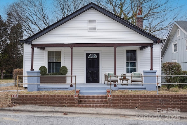 bungalow-style home featuring a porch and a chimney