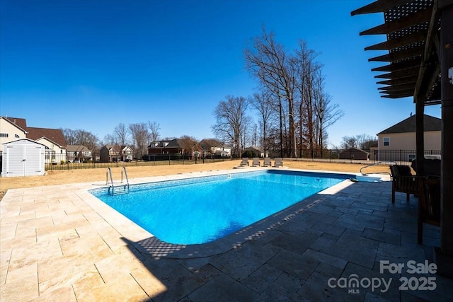 view of pool featuring a patio, a shed, fence, and a fenced in pool