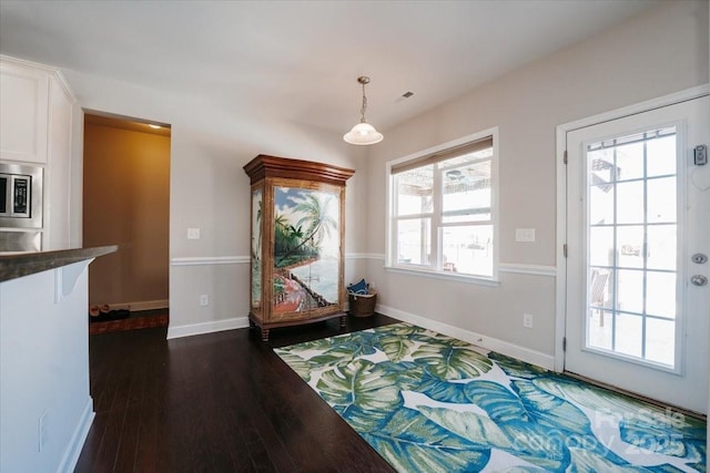 sitting room with dark wood finished floors, visible vents, and baseboards